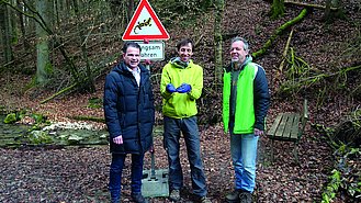 Drei Helfer vom Artenhilfsprogramm unter einem Schild, das vor der Salamanderwanderung warnt (Foto: BN/LBV)